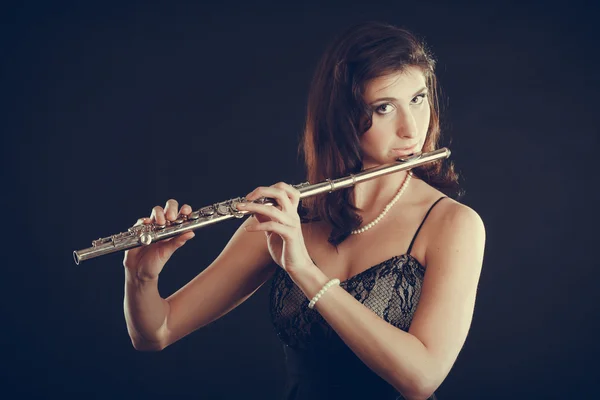 Žena hrající příčnou flétnu na černém pozadí. — Stock fotografie