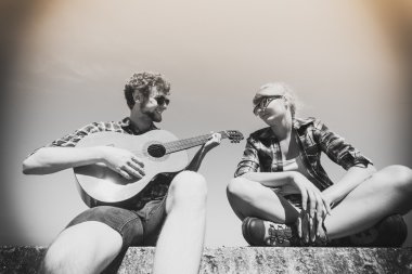 Genç kadın için gitar çalmak hipster adam.