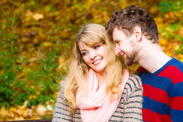 Lovers couple in autumn park on bench — Stock Photo, Image