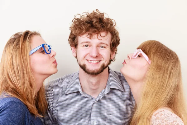 Duas mulheres bonitas beijando homem bonito . — Fotografia de Stock