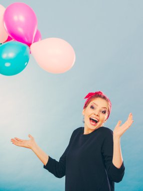 Balonlarla eğleniyor gülümseyen çılgın kız.