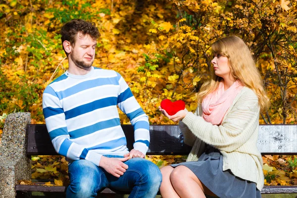 Kobieta wyznać miłość do człowieka na ławce w parku. — Zdjęcie stockowe