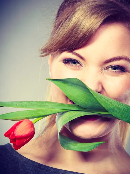 Glückliches Mädchen beißt Blume. — Stockfoto