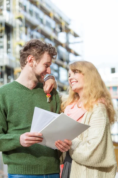 Par med blueprint projektet nycklar på byggarbetsplats — Stockfoto