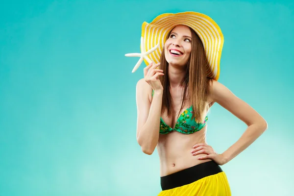 Mulher de chapéu amarelo segurando casca branca — Fotografia de Stock