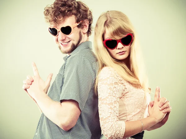 Couple man and woman making gun gesture.