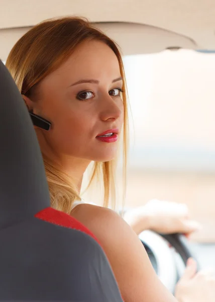 Mujer conduciendo coche con auriculares — Foto de Stock