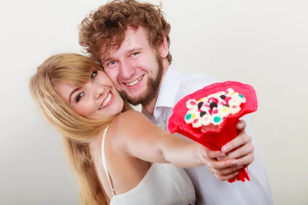 Glückliches Paar mit Süßigkeiten Strauß Blumen. Liebe. — Stockfoto