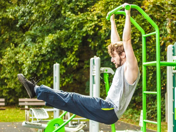 Aktiver Mann trainiert im Outdoor-Fitnessstudio. — Stockfoto