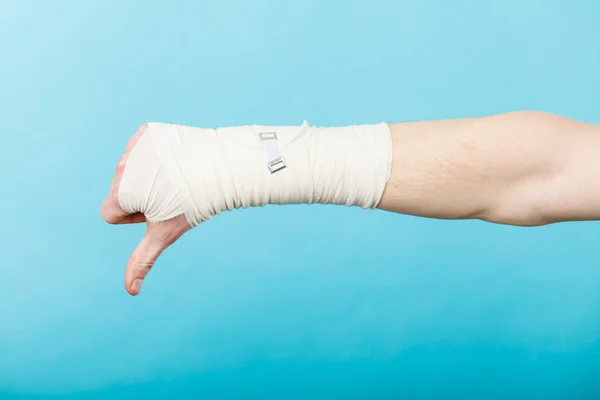 Manliga bandagerade hand med tummen ner tecken. — Stockfoto