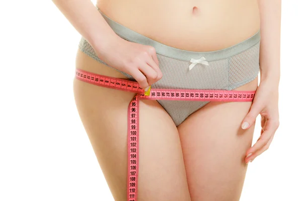 Femme en lingerie mesurant ses hanches avec du ruban à mesurer . — Photo