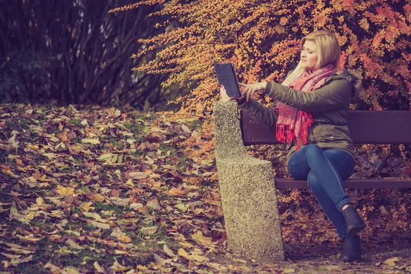 Женщина Расслабляется Сидя Скамейке Парке Осеннюю Погоду Помощью Планшетного Проверяя — стоковое фото