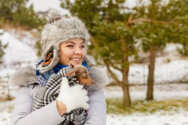 Genç bir kadın soğuk kış gününde en iyi arkadaşını sıcak battaniye eşarbına sardı. Hayvan koruma programı. Evlat edinme kavramı