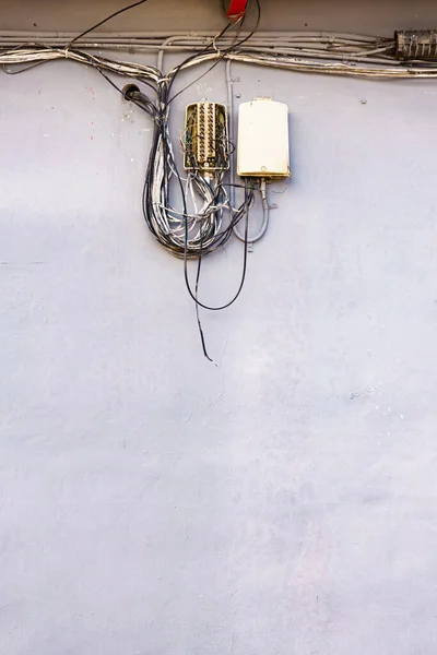 Cable power cords in tangled mess on building wall outdoor