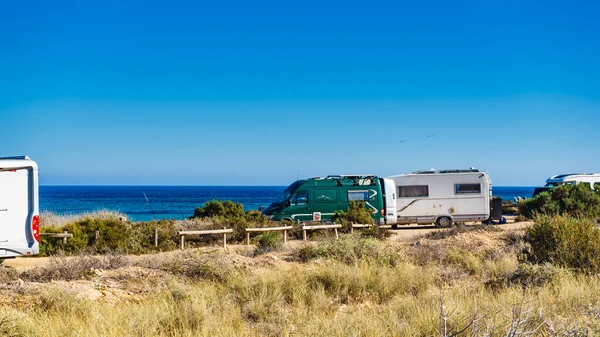 Camper, recreational vehicle on sea coast in Spain. Camping on nature beach. Holidays and traveling in motor home.