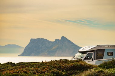 İspanya 'da Akdeniz kıyısında bir karavan. Ufukta Cebelitarık kayası görünüyor. Doğada kamp yapmak. Tatil ve seyyar evlerde seyahat.
