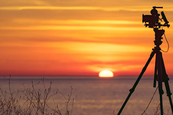 Tripod Üzerindeki Profesyonel Kamera Deniz Üzerinde Güneşin Doğuşunu Gösteren Bir — Stok fotoğraf