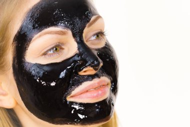 Yüzünde kozmetik olan genç bir kadın, karbonhidrat temizleme maskesi. Spa tedavisi. Cilt bakımı.