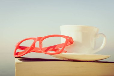 Tatillerde kitap okumak. Kahve fincanı ve açık havada kitap. Dinlenme dinlenme tatili kavramı.