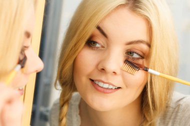 Makyaj yapan, kirpiklerini fırçalayan, kirpiklerini fırçalayan kadınların yakın çekim görüntüleri..