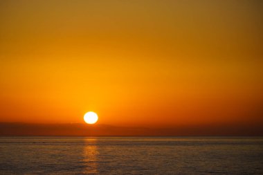Denizde gün batımı. Güneş ufuktan kayıyor.