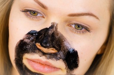 Yüzüne karbonhidrat maskesi takan genç bir kadın. Genç kız yağlı cildiyle ilgileniyor, gözenekleri temizliyor. Spa tedavisi. Cilt bakımı.