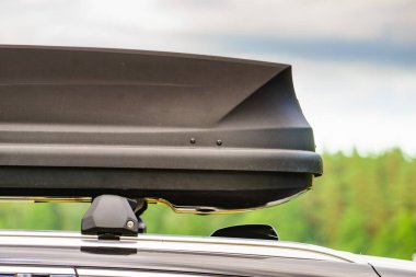 Arabanın çatısında bagaj ya da kargo kutusu var. Seyahat, aile tatili. Ulaşım için aksesuarlar.