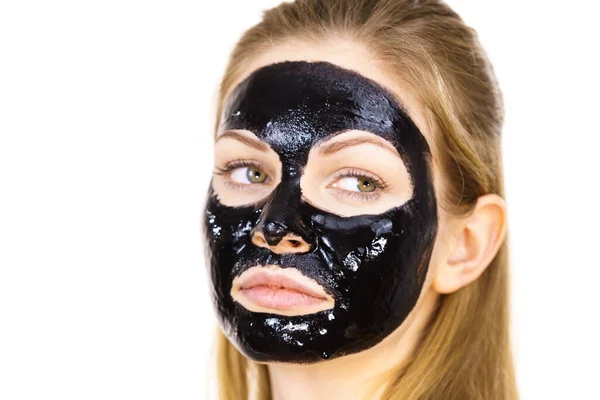 顔に化粧品を持つ若い女性は カルボデトックスマスクオフブラックピール スパトリートメント スキンケア — ストック写真