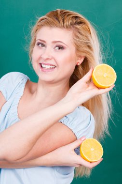 Sağlıklı beslenme, vitamin dolu ferahlatıcı yiyecekler. Lezzetli narenciye meyvesi tutan kadın, limon yarısı.