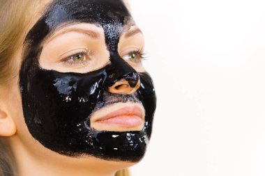 Yüzünde kozmetik olan genç bir kadın, karbonhidrat temizleme maskesi. Spa tedavisi. Cilt bakımı.