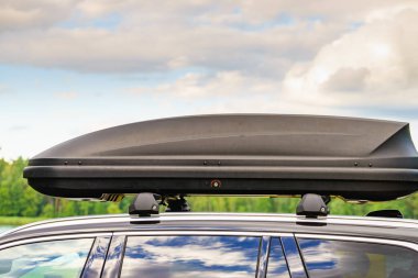Arabanın çatısında bagaj ya da kargo kutusu var. Seyahat, aile tatili. Ulaşım için aksesuarlar.