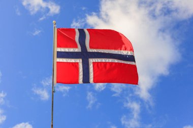 Mavi gökyüzünde dalgalanan Norveç bayrağı