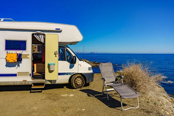Wild camping on sea shore. Camper car rv with clothes hanging to dry. Holidays with motor home.