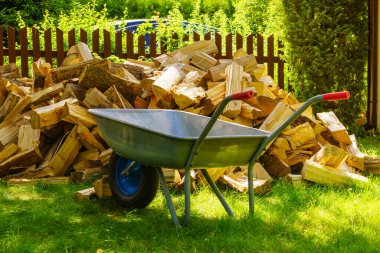 Dışarıda odun yığını ve el arabası var. Kış için hazırlık.