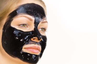 Yüzünde kozmetik olan genç bir kadın, karbonhidrat temizleme maskesi. Spa tedavisi. Cilt bakımı.