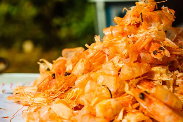 Seafood, ocean food. Pile of shrimps heads and shells. Peeling raw fresh shrimp.
