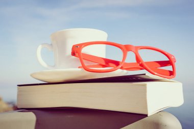 Tatillerde kitap okumak. Kahve fincanı ve açık havada kitap. Dinlenme dinlenme tatili kavramı.