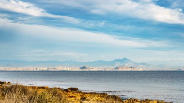 Deniz manzarası. İspanyol plajı kayalık deniz kıyısı. Akdeniz 'de. Uzakta Alicante sahili.