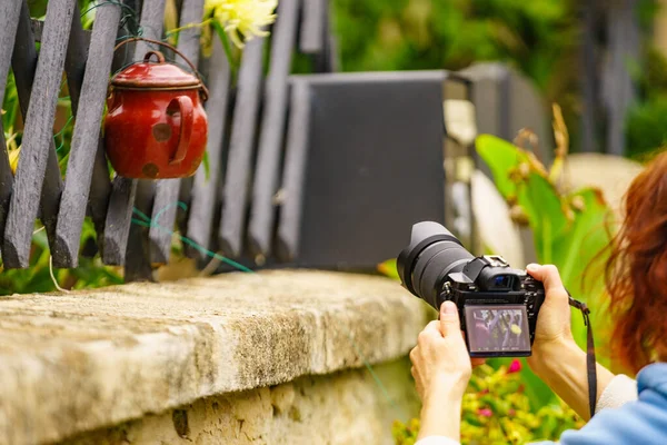 Wanita Dengan Kamera Mengambil Foto Dari Pagar Dengan Pot Merah — Stok Foto
