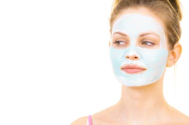 Yüzünde yeşil çamur maskesi olan genç bir kadın, beyaz. Genç kız yağlı cildiyle ilgileniyor, gözenekleri temizliyor. Güzellik tedavisi. Cilt bakımı.