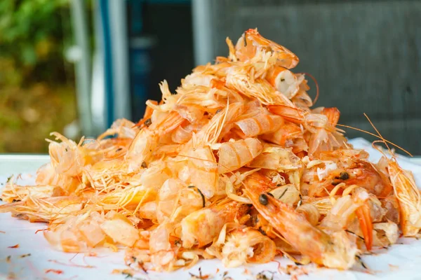 Seafood, ocean food. Pile of shrimps heads and shells. Peeling raw fresh shrimp.