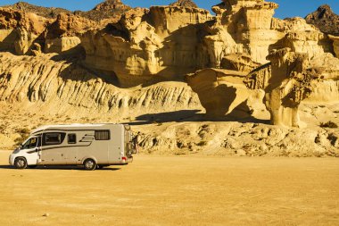 Aşınmış sarı kumtaşı oluşumlarındaki park yerinde kamp arabası, Büyülü Şehir Bolnuevo, Murcia İspanya. Turist eğlencesi.