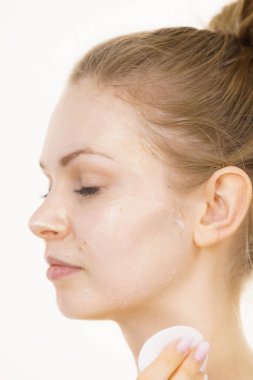 Yüzünde maske olan genç bir kadın pamuklu bezle kozmetiği temizliyor. Cildiyle ilgilenen genç bir kız. Güzellik tedavisi. Cilt bakımı.