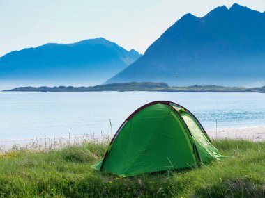 Yazın deniz kıyısında çadır. Okyanus kıyısında kamp yapmak. Lofoten takımadaları Norveç. Tatil ve seyahat.