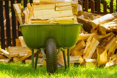 Dışarıda odun yığını ve el arabası var. Kış için hazırlık.