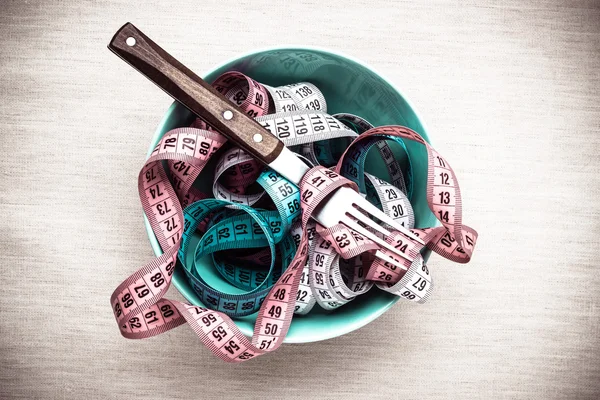 Many measuring tapes in bowl on table — Stock Photo, Image