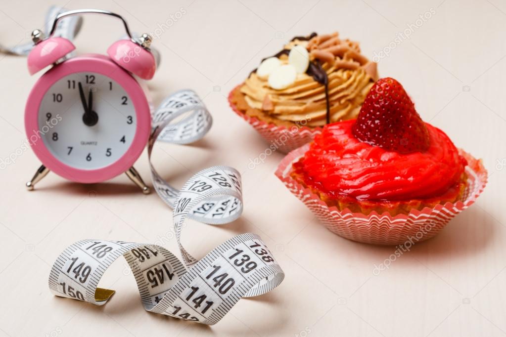 Sweet food measuring tape and clock on table