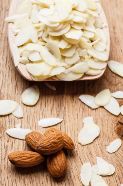dilimlenmiş ve tüm çiğ badem ahşap yüzey üzerinde