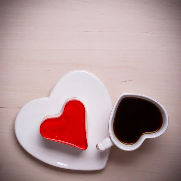 Heart shaped coffee cup and cake on wood surface — Stock Photo, Image