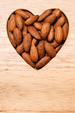 Badem ahşap yüzey zemin üzerinde kalp şeklinde